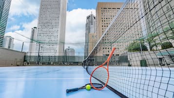 A tennis court with a net, a tennis racket, and a ball.