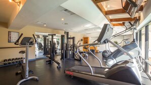 A gym with treadmills, weight machines, and dumbbells.