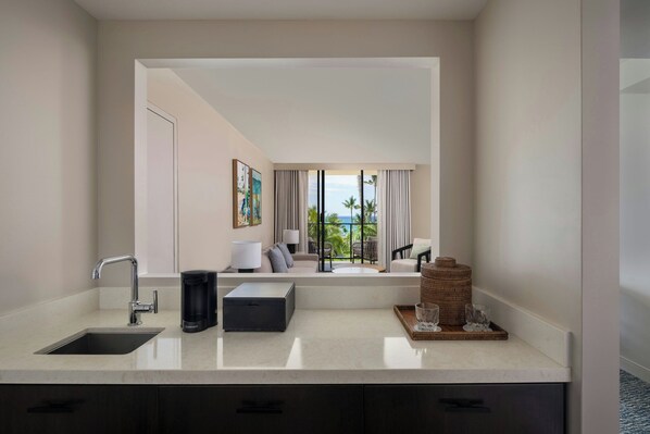 A modern bathroom with a large mirror, a sink, and a window overlooking a balcony with outdoor furniture. - Waikoloa Beach Marriott Resort & Spa (Waikoloa)