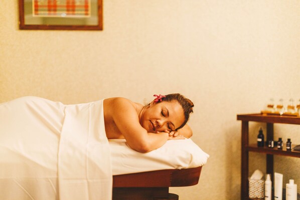 A person lying on a bed in a room with a shelf of toiletries. - Waikoloa Beach Marriott Resort & Spa (Waikoloa)