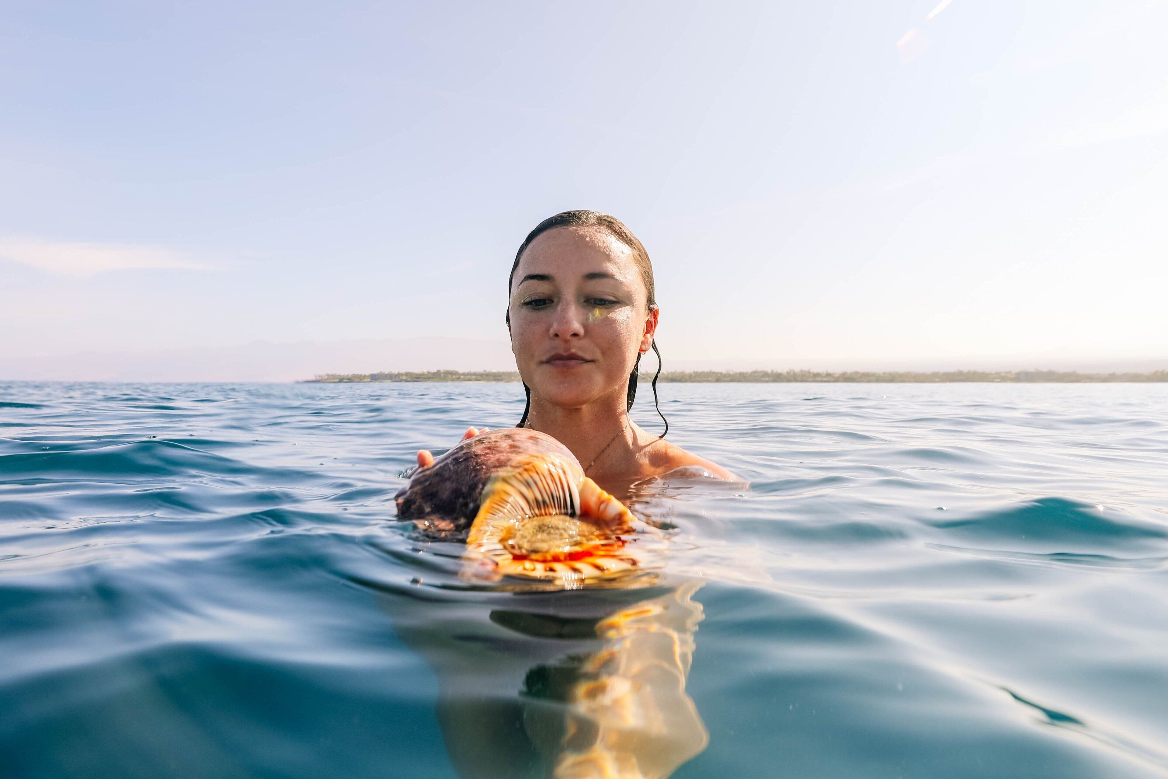 A person swimming in clear blue water with a sea turtle.