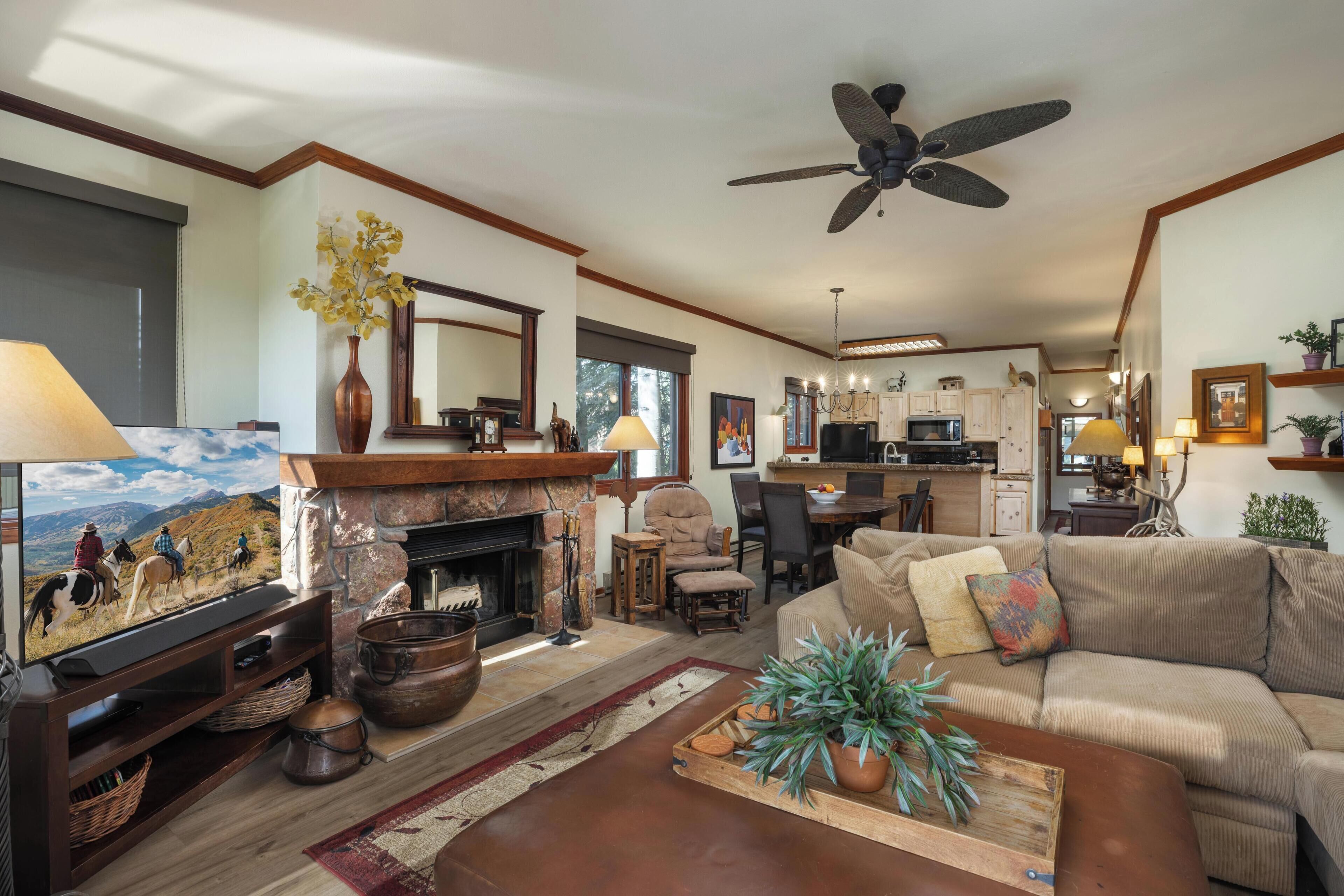 A cozy living room with a fireplace, comfortable seating, and a television.