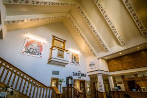 Eine Hotelhalle mit einer Treppe, einer Bar namens 'The Sandeman' und verschiedenen Wanddekorationen.