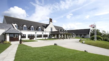 Stunning building with a central entrance and symmetrical facade, set amidst beautifully maintained lawns.