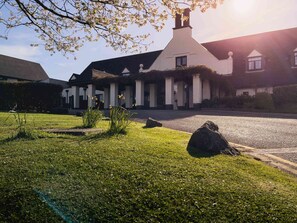 A building with a white facade, a chimney, and a driveway leading to the entrance. - Lancaster House Hotel (Lancaster)