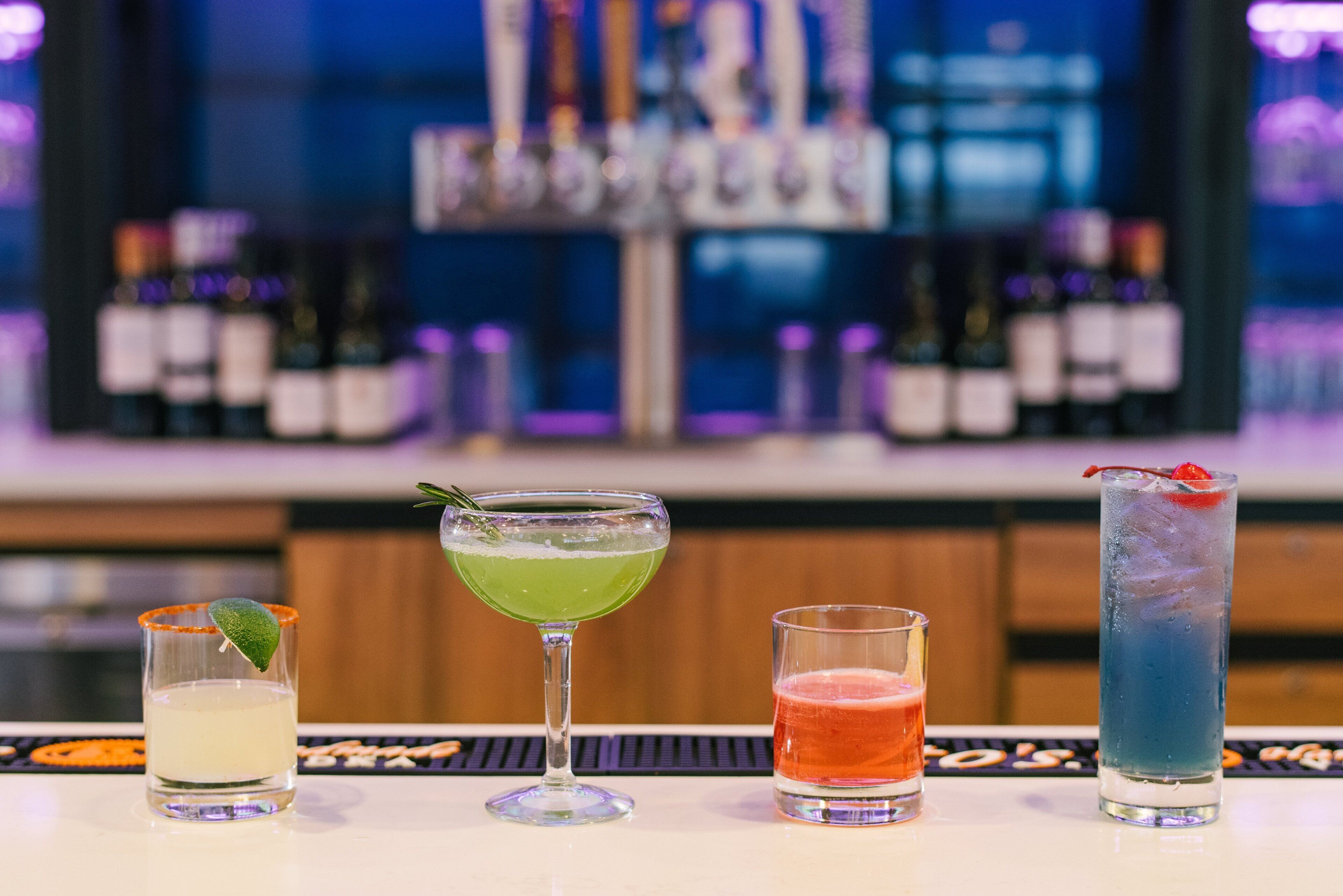 A bar area with four different cocktails.
