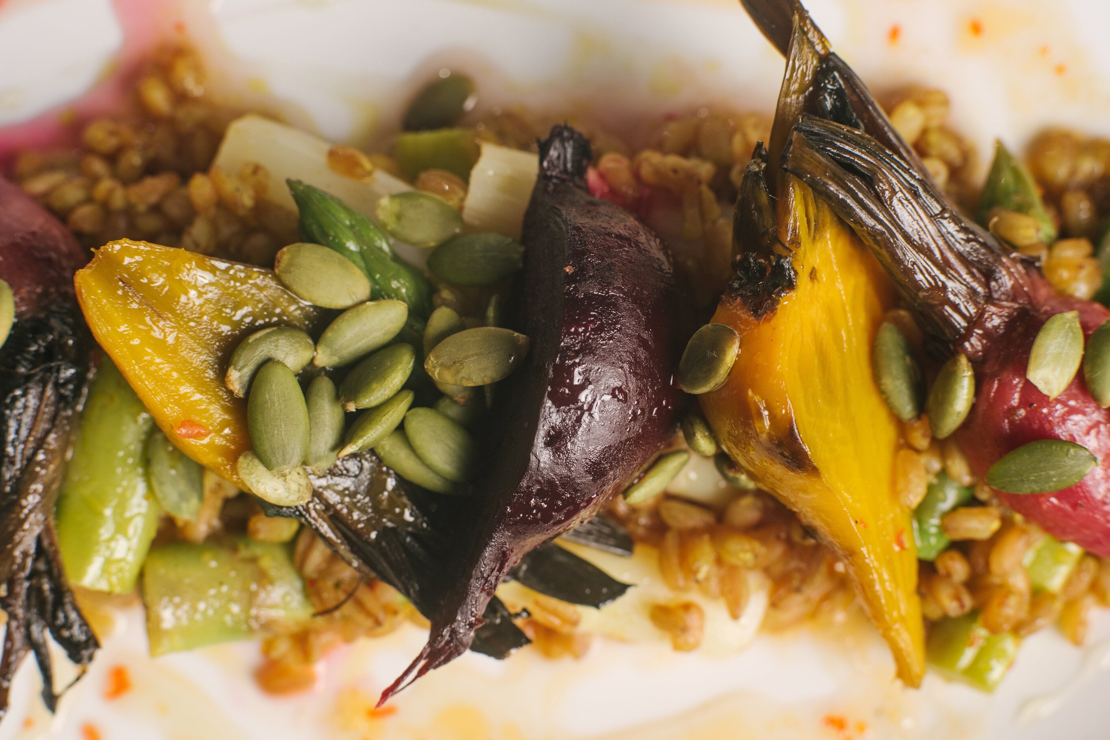 A close-up of a dish with various vegetables and seeds.