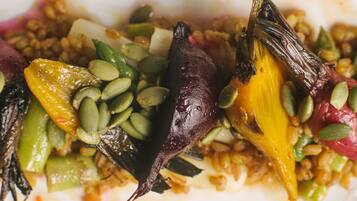 A close-up of a dish with various vegetables and seeds.