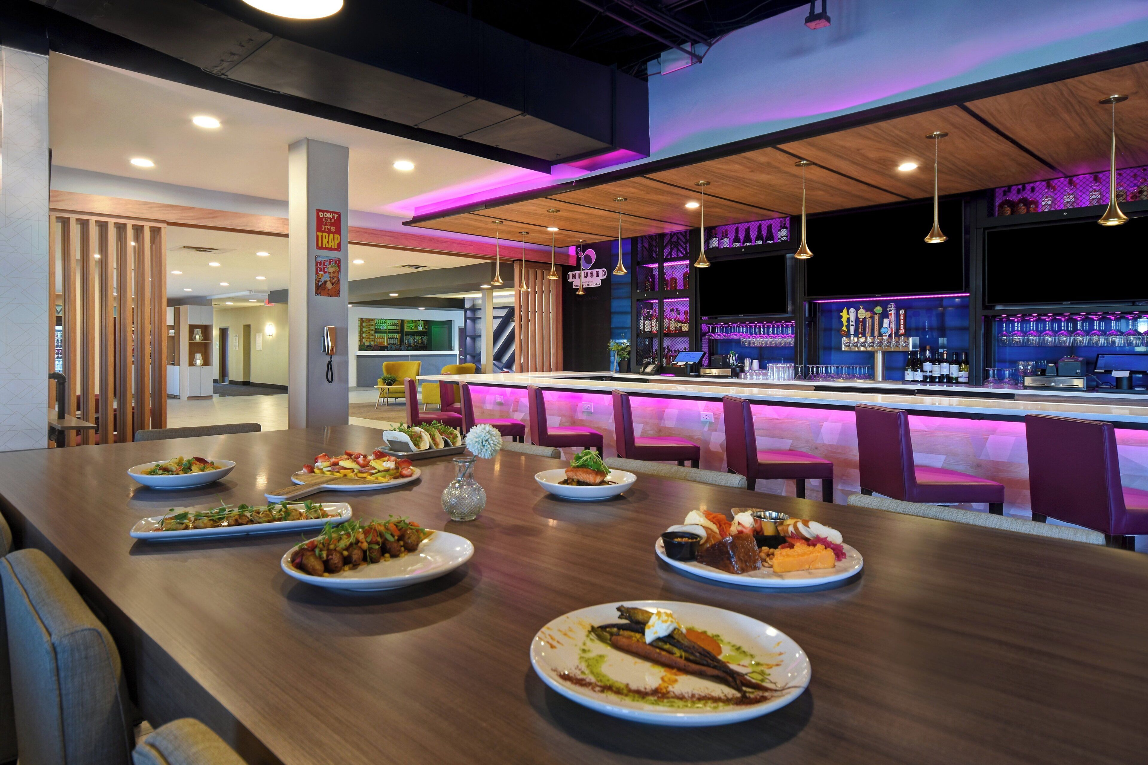 A restaurant with a bar area, multiple dining tables, and a variety of dishes.
