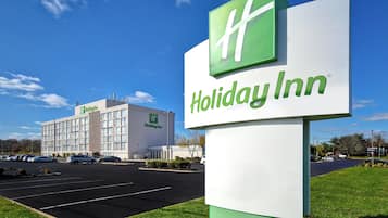 A Holiday Inn sign with a large building in the background.
