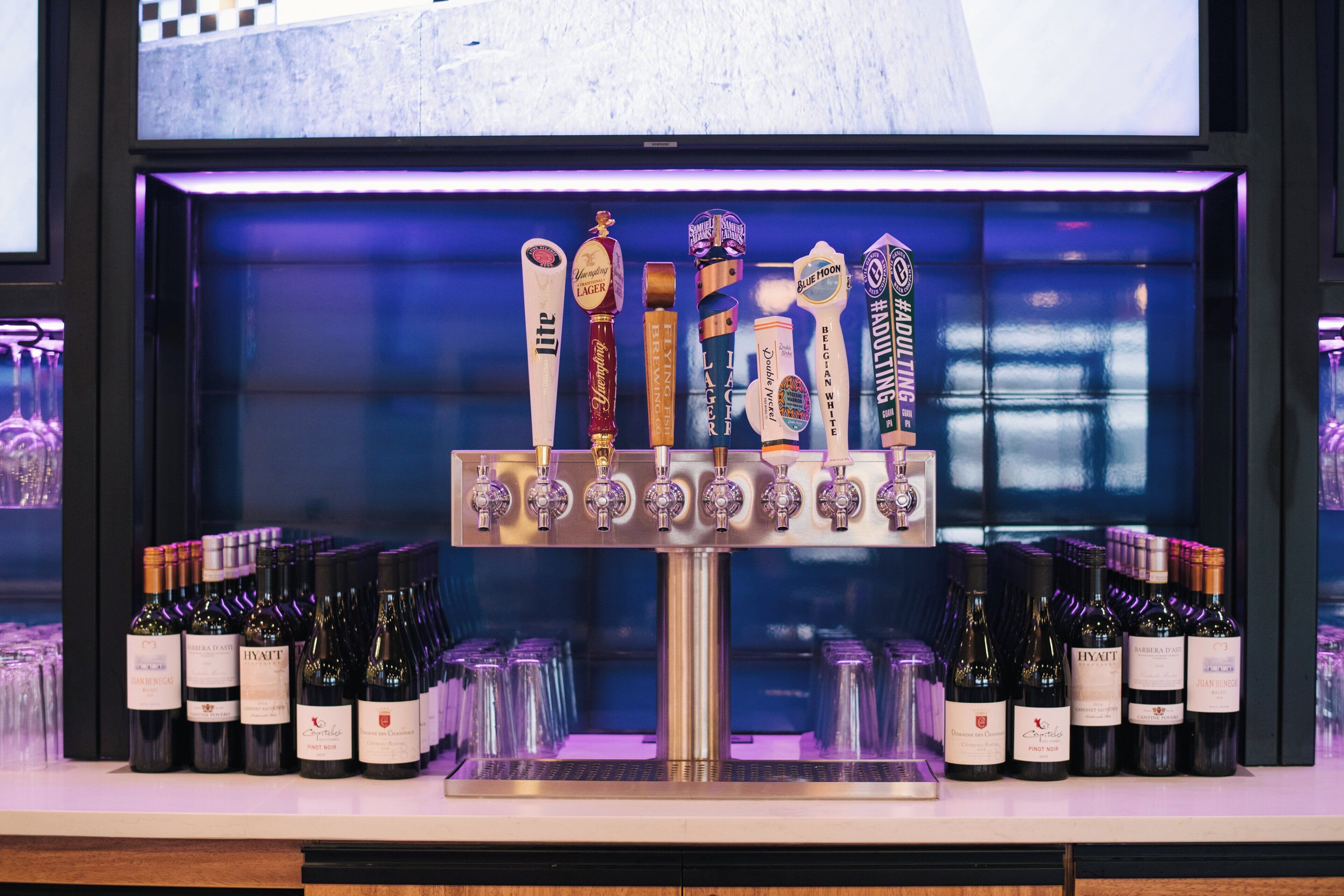 A bar area with a tap display featuring various beer and wine options.
