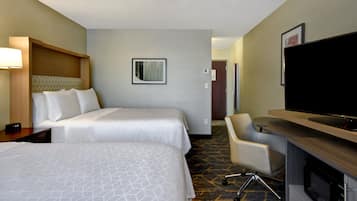 Quarto de hotel com duas camas, uma escrivaninha com televisão de tela plana, uma cadeira e um micro-ondas.