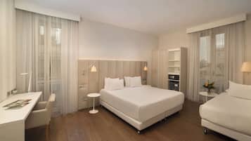 Ein modernes Hotelzimmer mit einem großen Bett, einem Schreibtisch und einem kleinen Tisch.