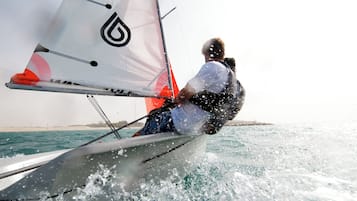 A person sailing a boat with a sail.