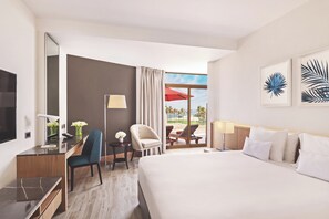 Habitación de hotel con cama, escritorio, silla y vistas al exterior.
