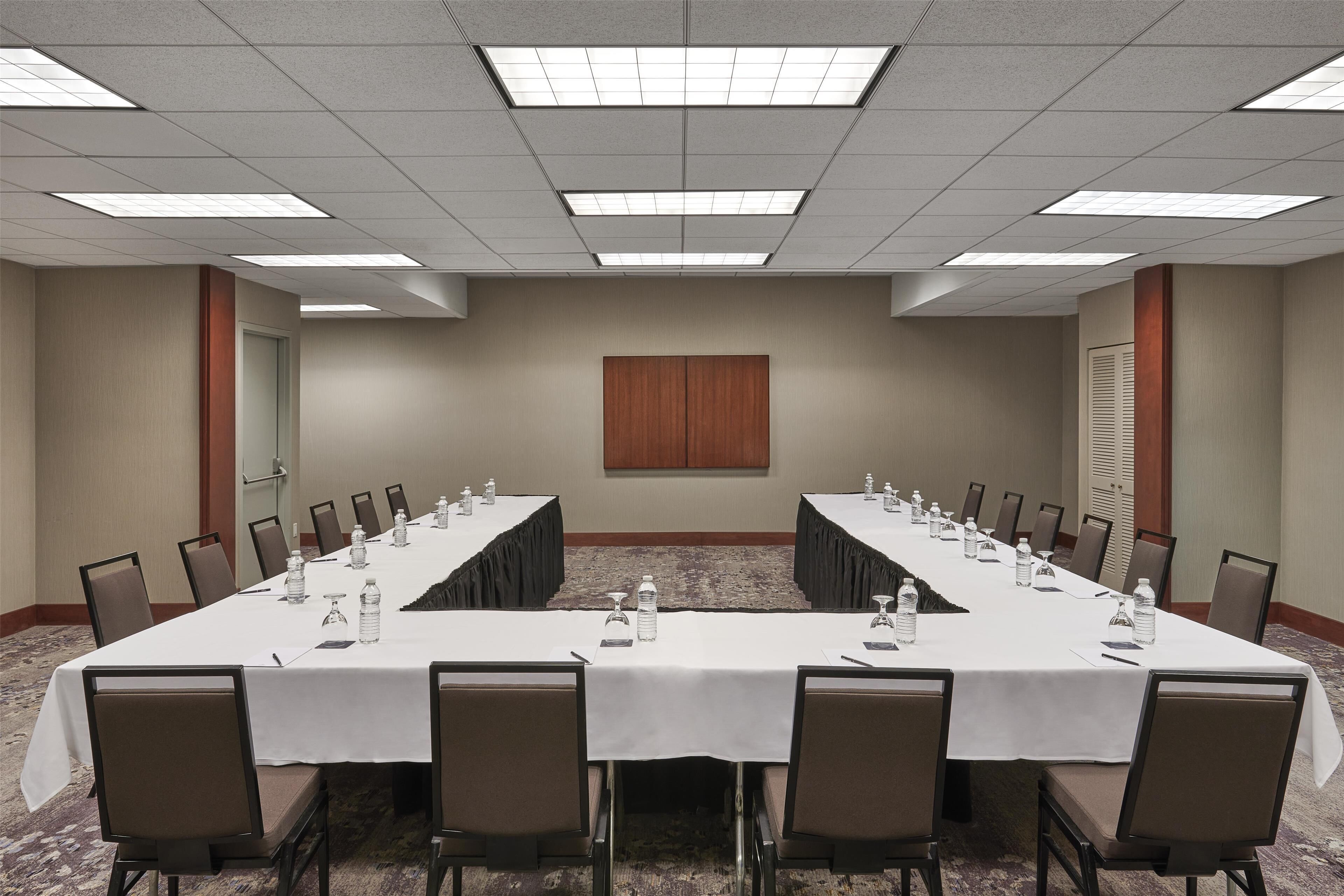 A conference room with a long table, chairs, and water bottles.