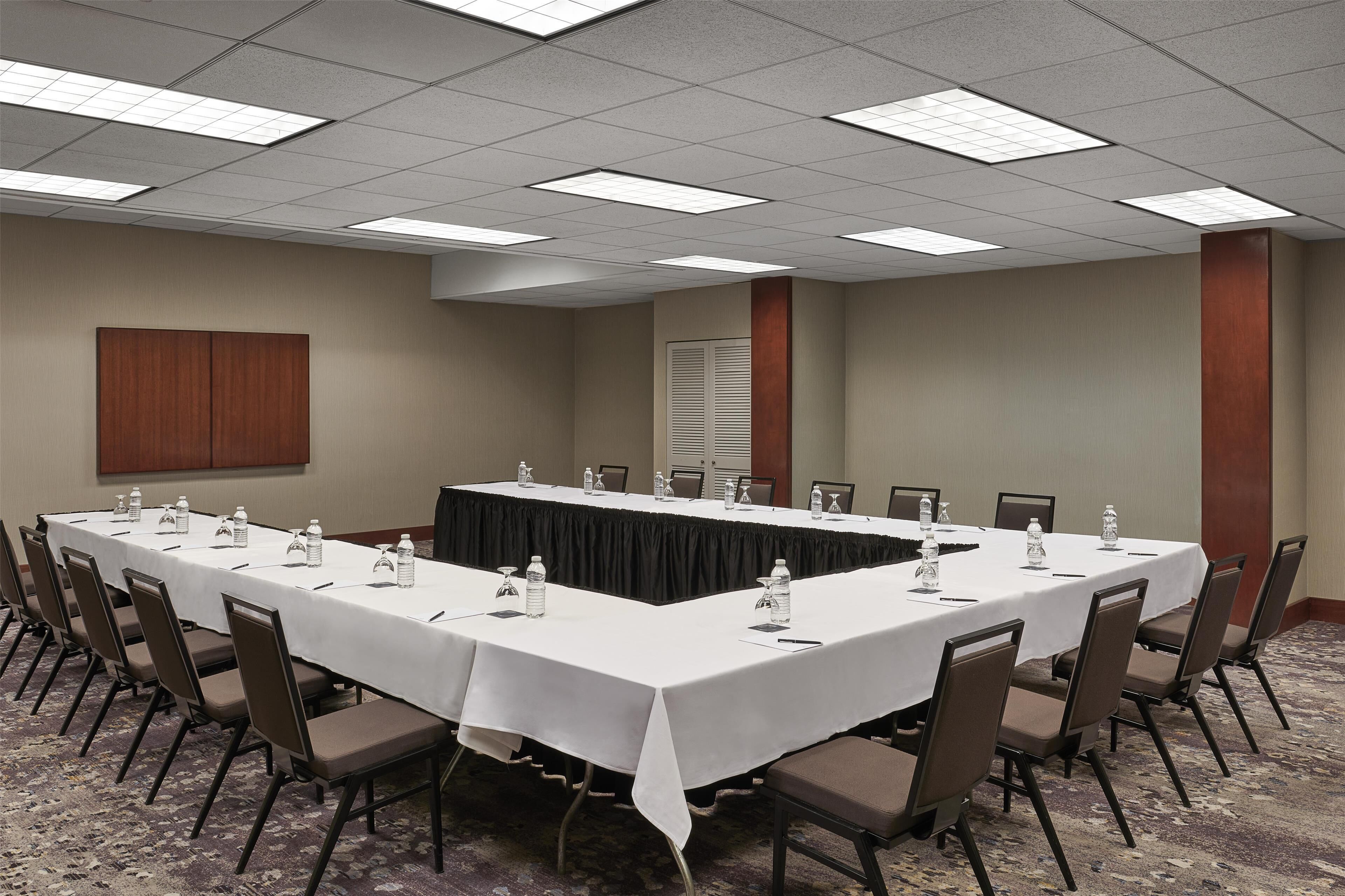 A conference room with a long table, chairs, and water bottles.
