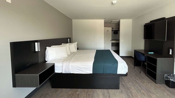 A modern hotel room with a large bed, a desk, a chair, and a TV. - Motel 6 Lake Elsinore, CA (Lake Elsinore)