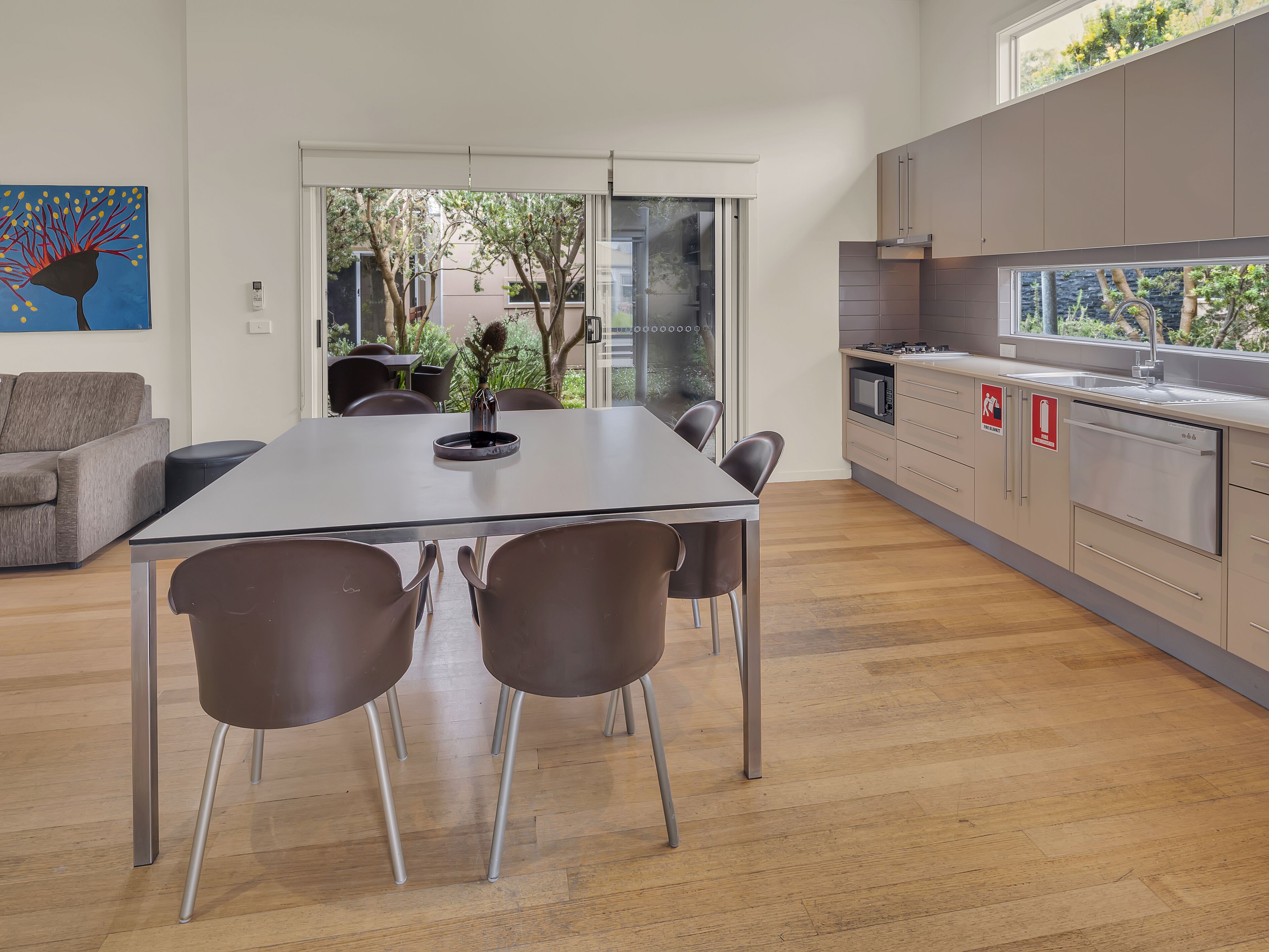 Una cocina moderna con una isla grande, electrodomésticos de acero inoxidable y vistas al exterior.