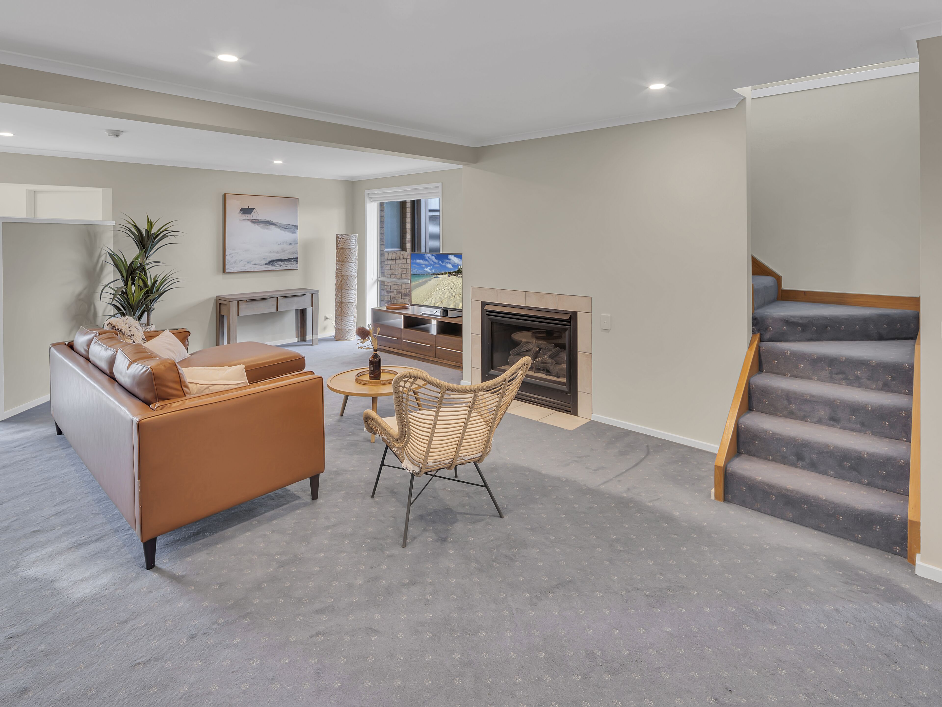A modern living room with a sofa, a coffee table, and a fireplace.