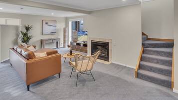 A modern living room with a sofa, a coffee table, and a fireplace.