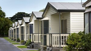 A row of single-story mobile homes with a uniform design, featuring front porches and a simple, functional layout. - BIG4 Ingenia Holidays Queenscliff Beacon (Queenscliff)