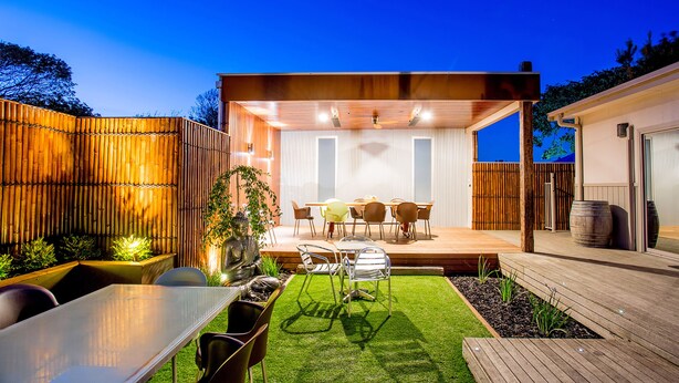 A modern outdoor patio with a dining area, wooden deck, and a covered seating area. - BIG4 Ingenia Holidays Queenscliff Beacon (Queenscliff)