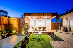A modern outdoor patio with a dining area, wooden deck, and a covered seating area. - BIG4 Ingenia Holidays Queenscliff Beacon (Queenscliff)