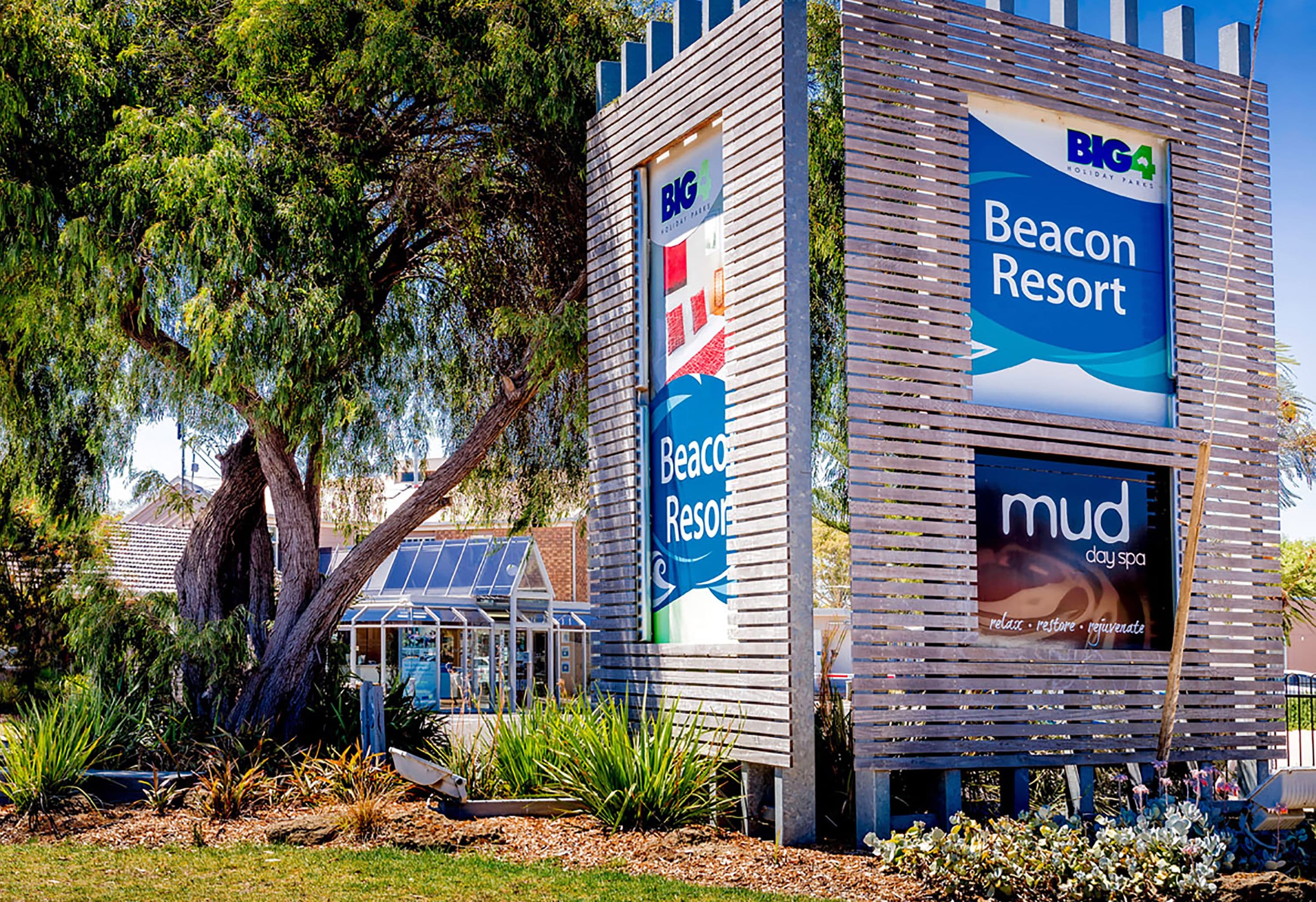 Ein modernes Gebäude mit Schildern für Beacon Resort und Mud Day Spa.