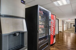 Máquina expendedora con el logotipo de Coca-Cola, una pantalla digital y una variedad de bocadillos.