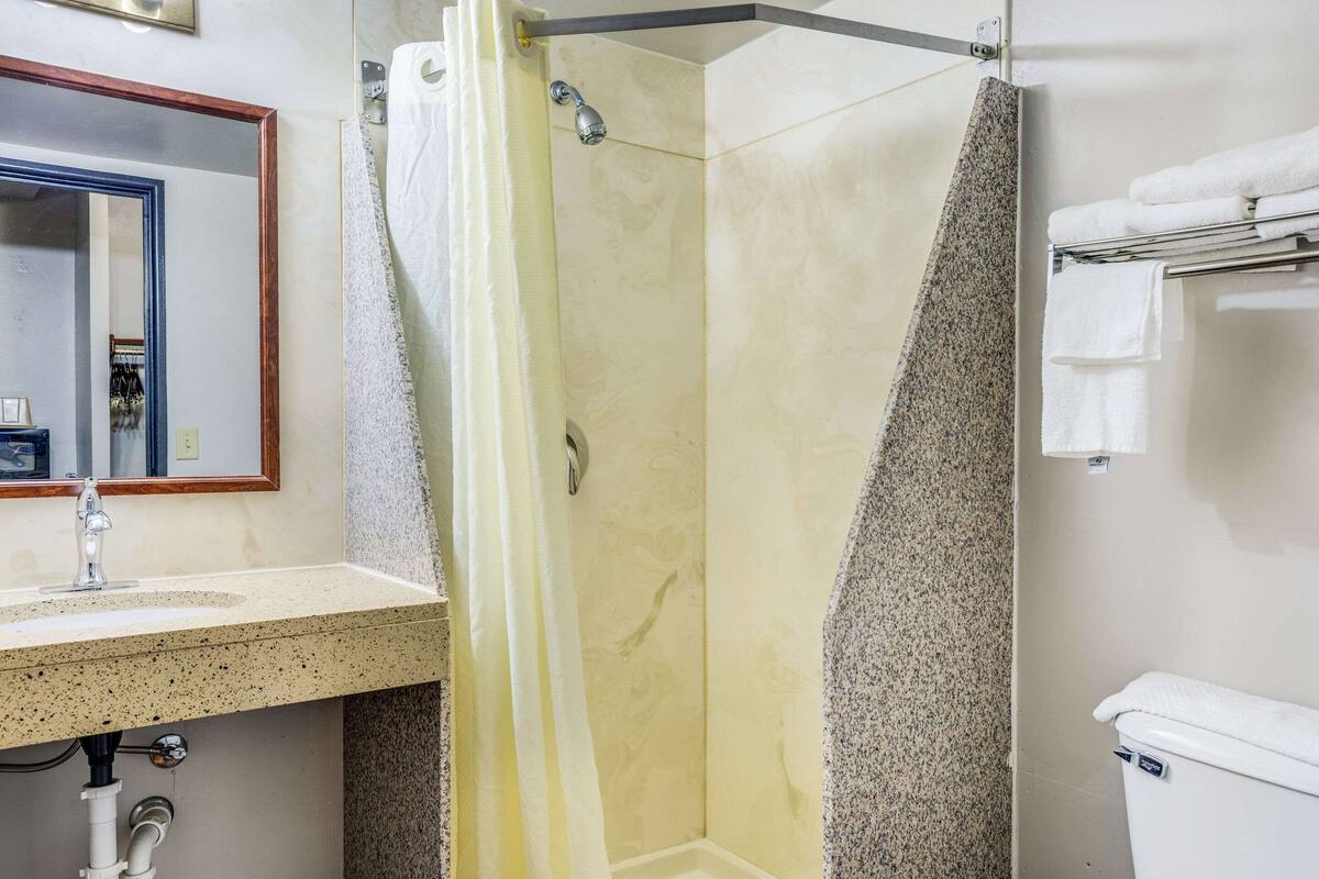 Un baño con ducha, lavabo e inodoro.
