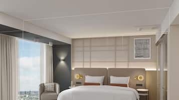 Una habitación de hotel moderna con una cama grande, zona de estar y vistas a la ciudad.