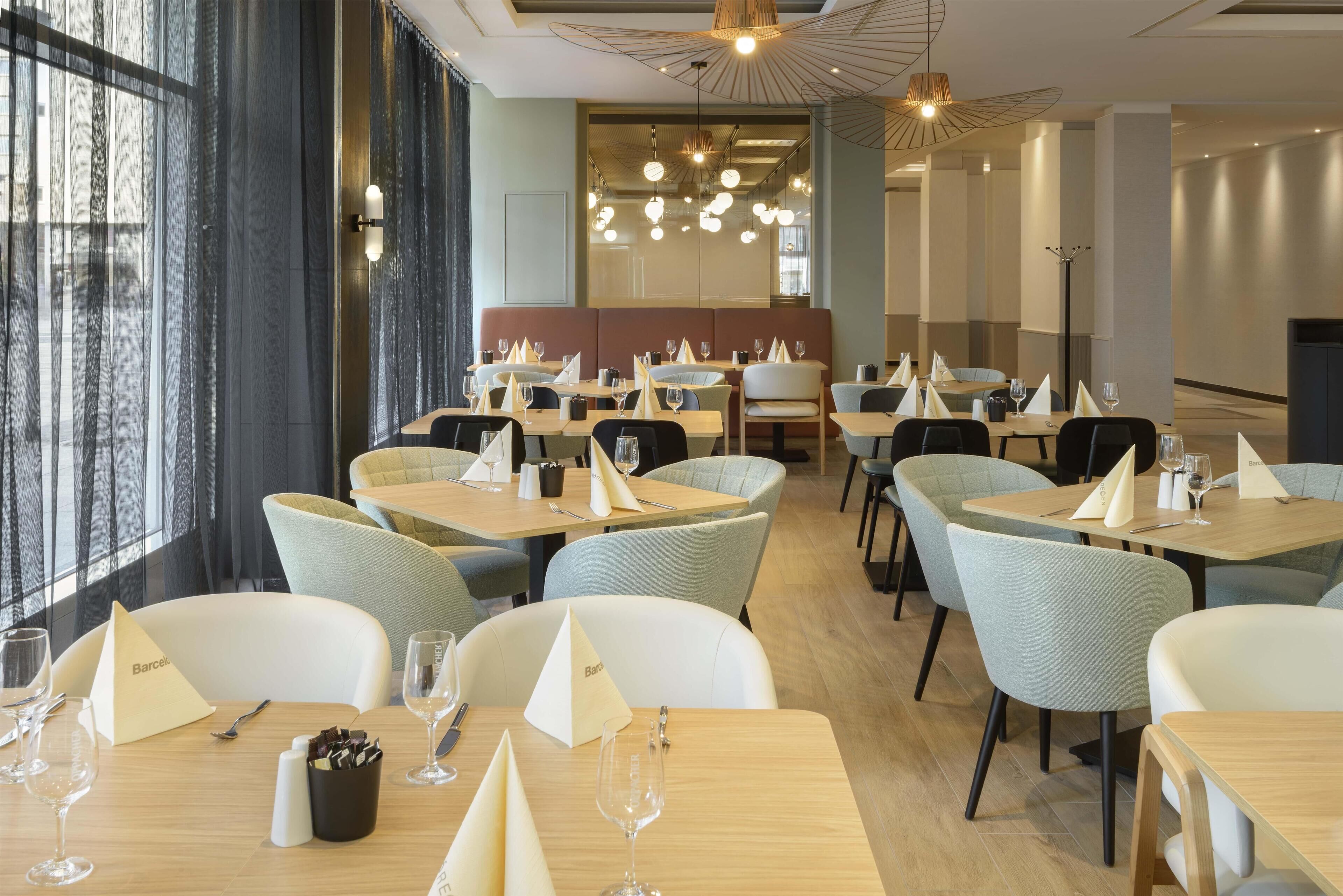 Un restaurante con mesas dispuestas para comer, sillas y una decoración interior moderna.