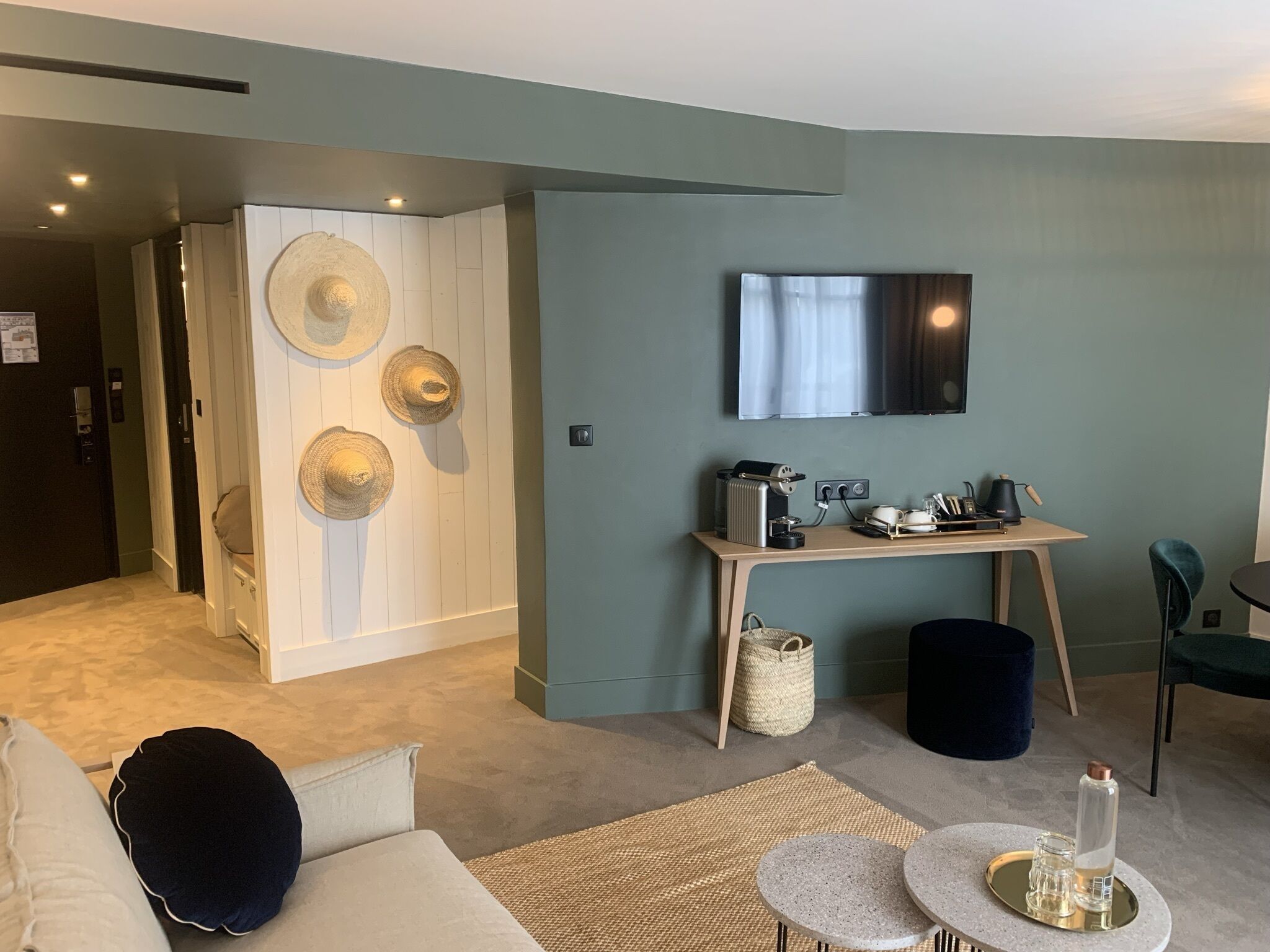Una sala de estar moderna con un sofá, una mesa de centro y un televisor montado en la pared.