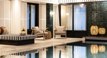 室内游泳池，池畔遮阳伞，日光浴躺椅