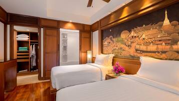 A hotel room with two beds, a wardrobe, and a mural of a temple.