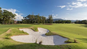 Enjoy a round of golf surrounded by lush greenery and majestic mountains.