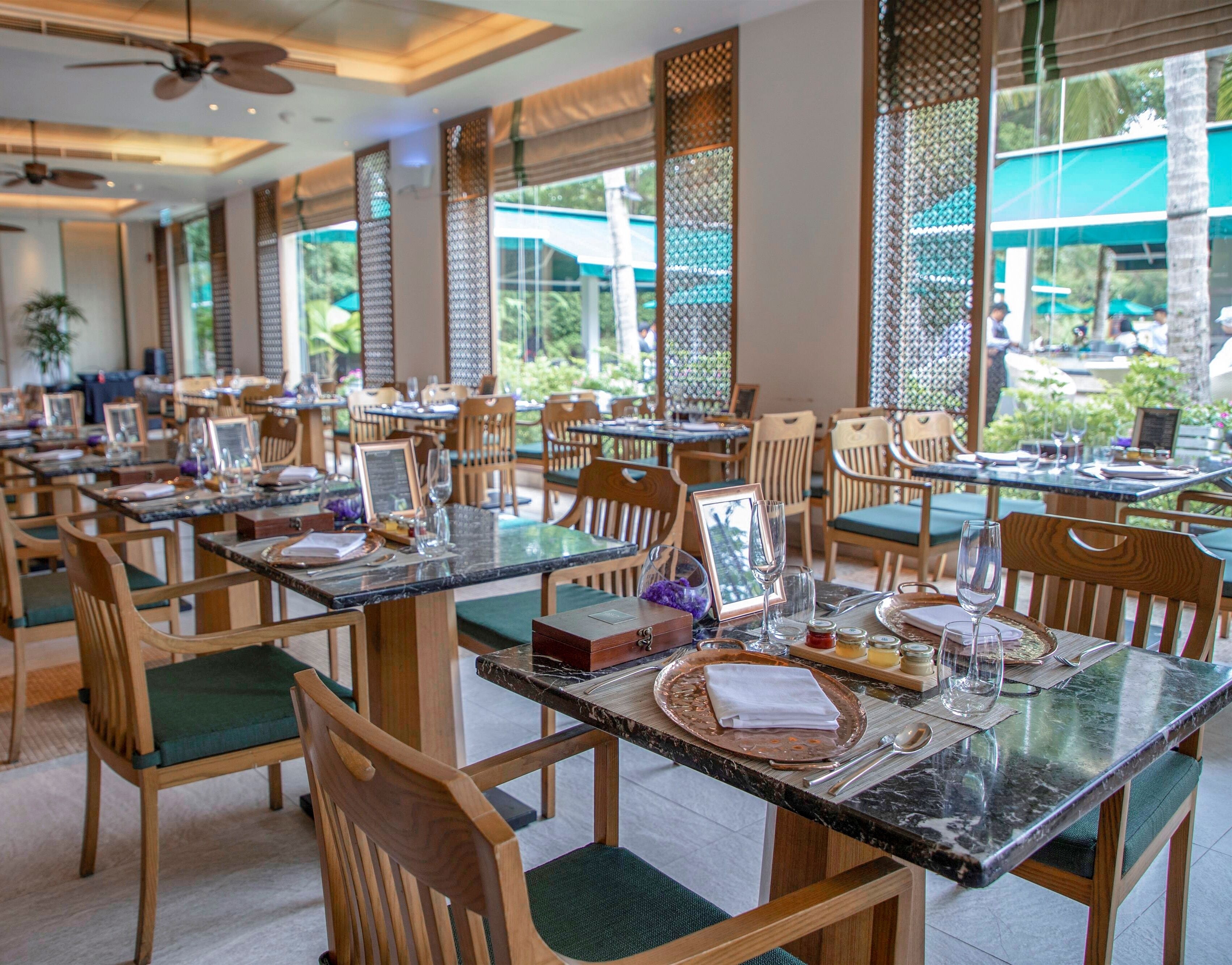 A restaurant with multiple tables, chairs, and a view of the outdoors.