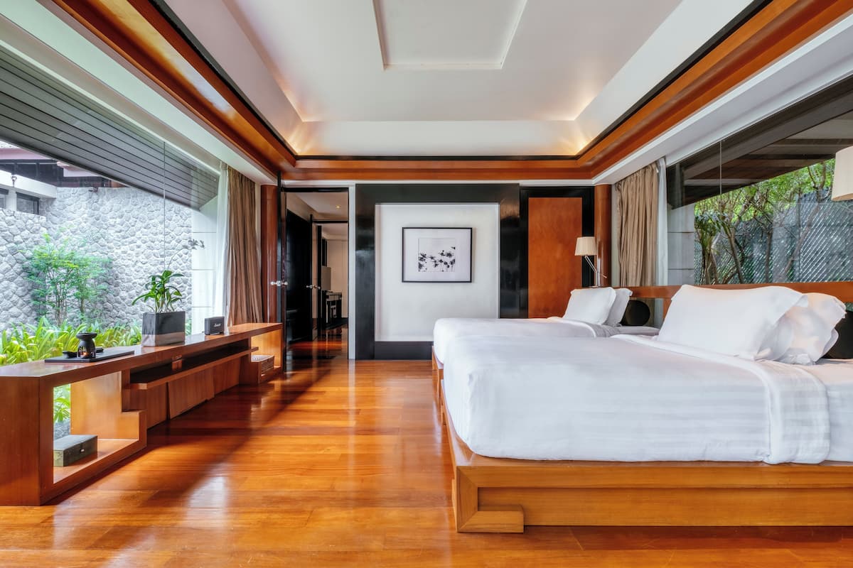 A modern bedroom with a wooden bed, a built-in desk, and a stone wall.