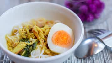 A bowl of noodle soup with a boiled egg and vegetables.