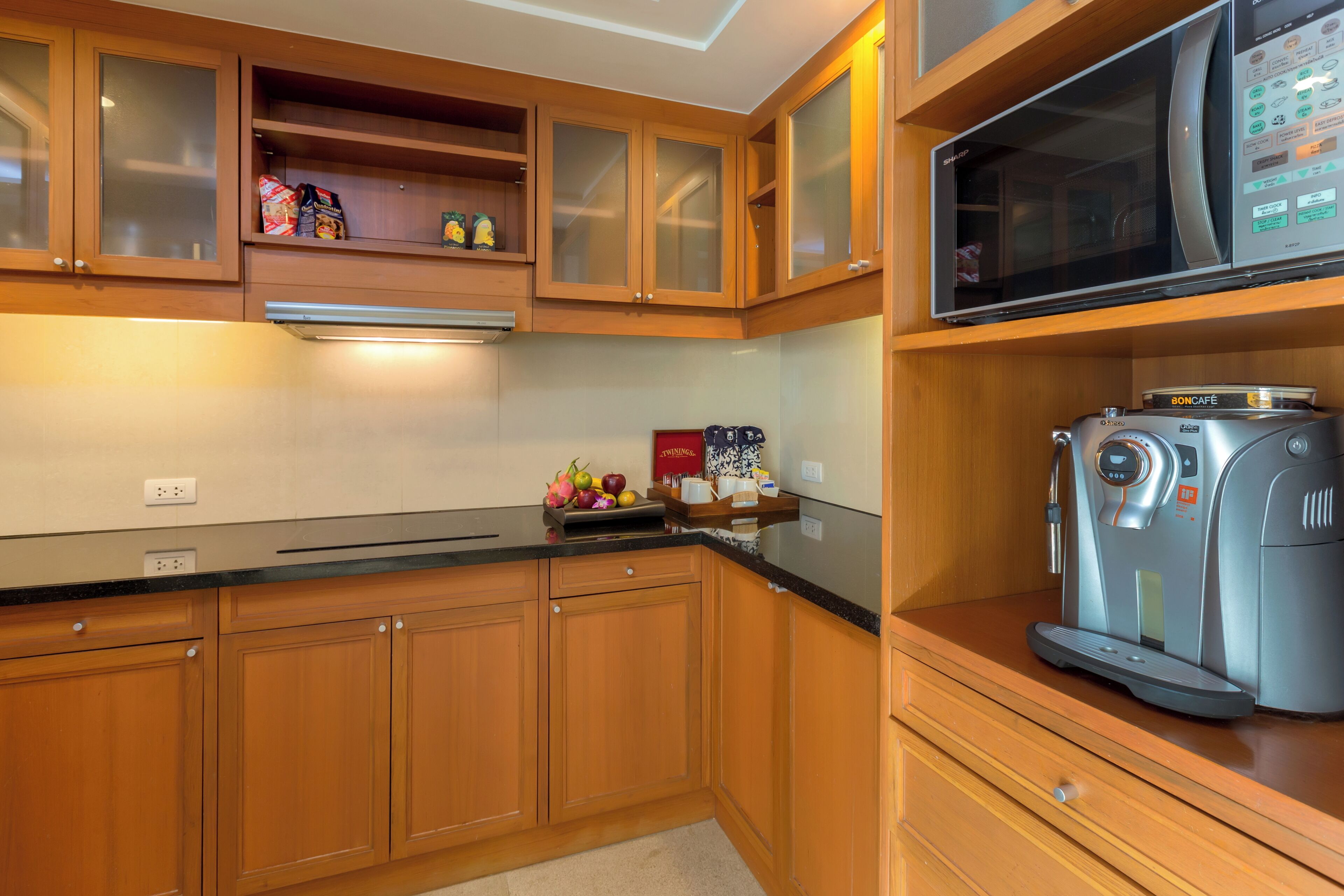 A kitchen with wooden cabinets, a microwave, and a coffee maker.