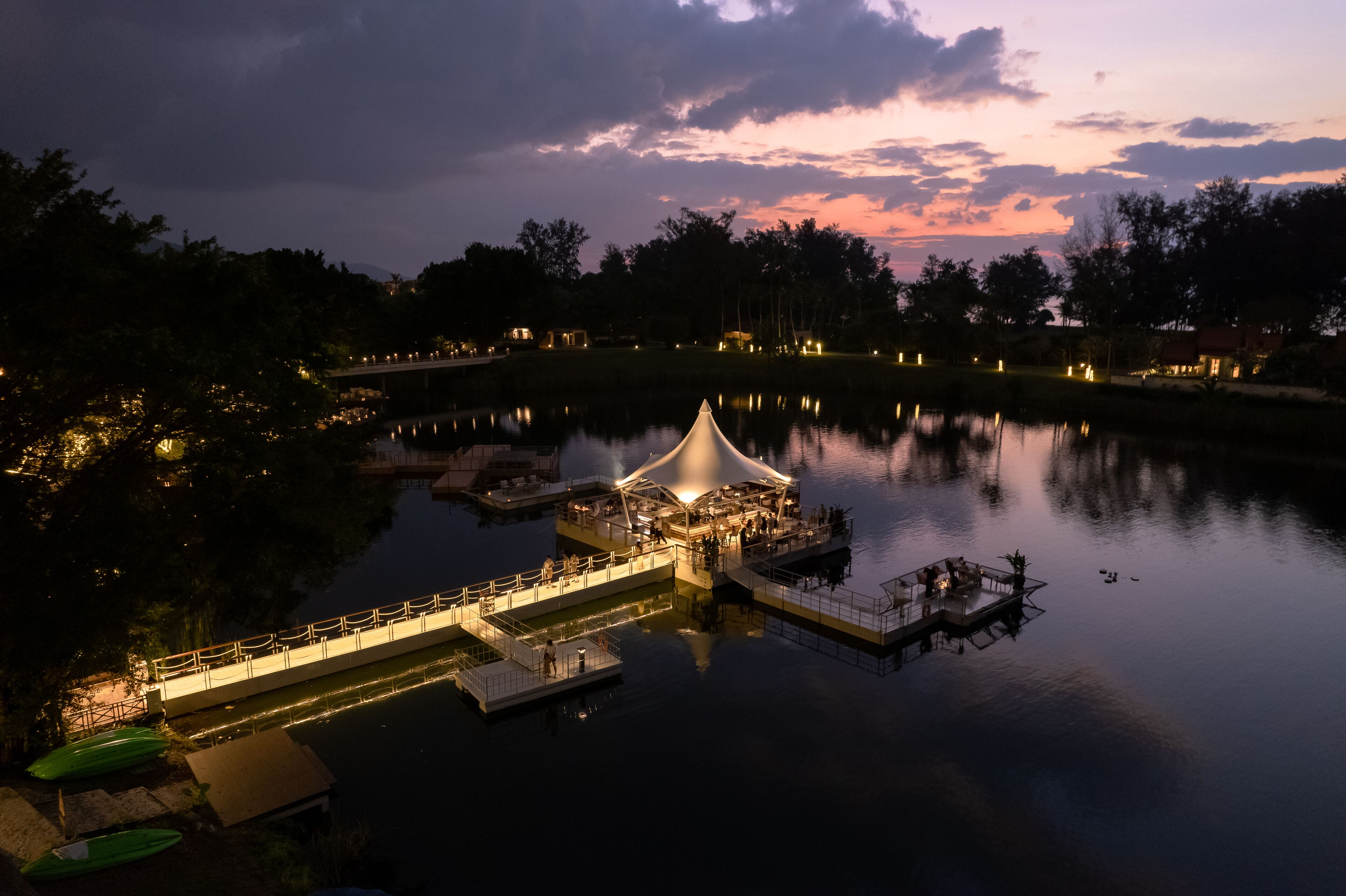 A lakeside resort with a covered dining area, a dock, and boats.