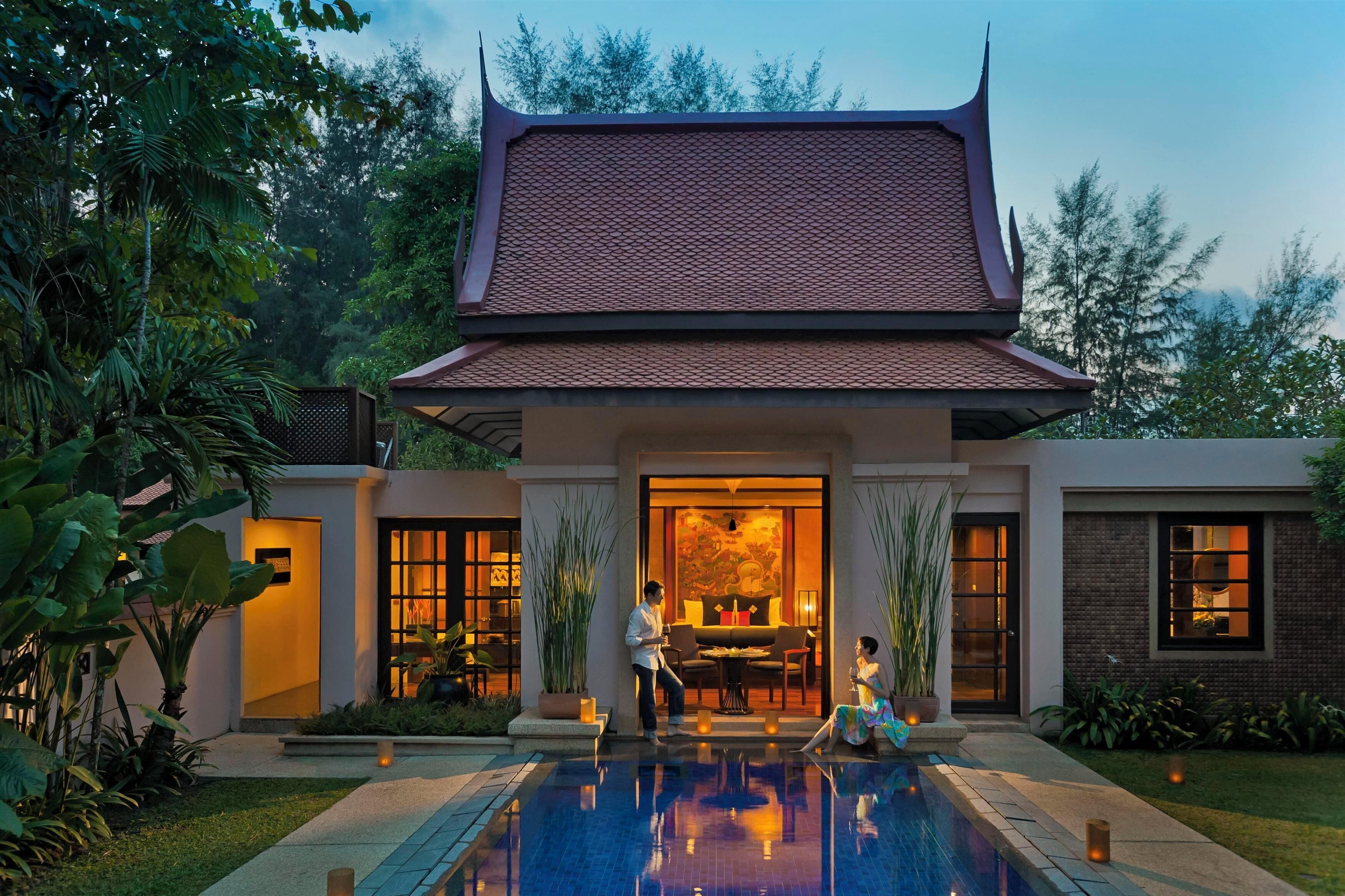 A traditional building with a tiled roof, a pool, and a well-maintained garden.