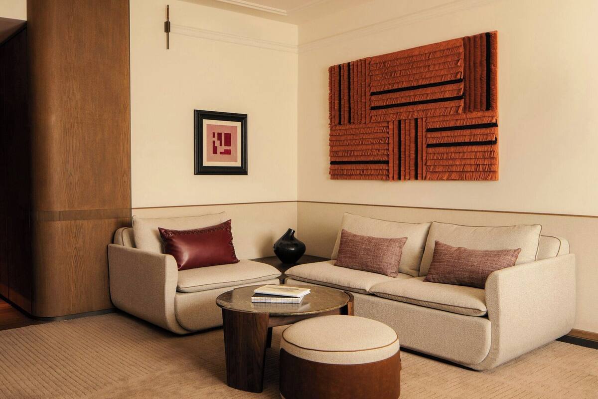 Una sala de estar moderna con un sofá, dos mesitas auxiliares y una mesa de centro.