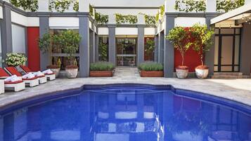 Una piscina al aire libre, tumbonas
