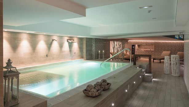 A modern spa area with a large pool, seating area, and a reception desk. - Catalonia Atenas (Barcelona)