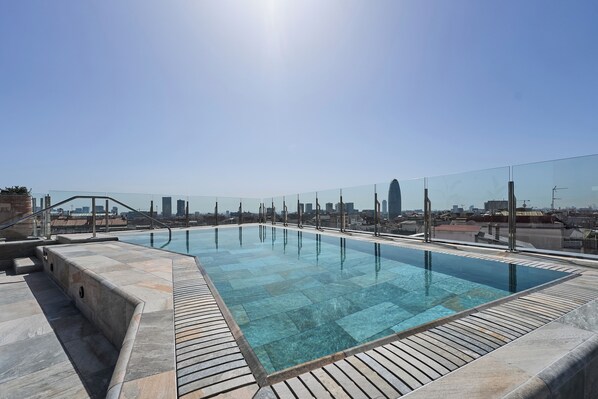 Una piscina al aire libre, sombrillas, tumbonas