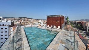 A rooftop pool with clear blue water, surrounded by lounge chairs and a wooden structure. - Catalonia Atenas (Barcelona)