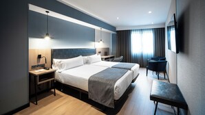 A modern hotel room with two beds, a desk, a chair, and a TV mounted on the wall. - Catalonia Atenas (Barcelona)