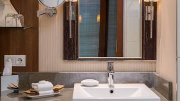 A bathroom with a white sink, a mirror, and two wall-mounted lights.